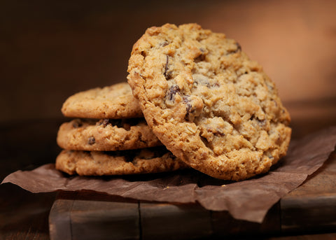 Stack of crispy, chewy oatmeal raisin cookies, with one cookie placed at an angle to show the top view